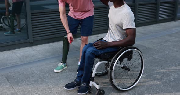 Multiracial friends with disability hugging each other outdoor