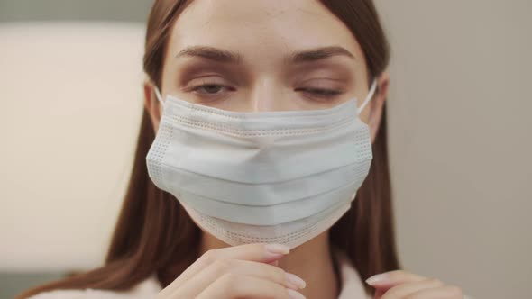 White Girl Puts on a Mask and Looks Into the Camera