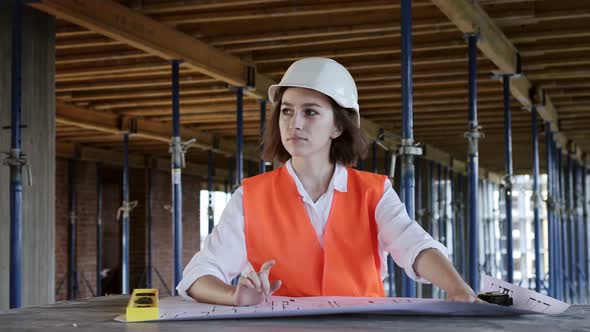 Architect working, browsing building project indoor of construction site with blueprint plan