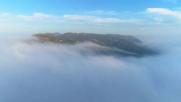 Aerial View Green Mountain Covered By Thick Fog Clouds at Sunrise. Malibu, USA