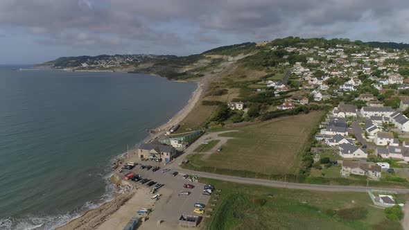 The village of Charmouth and the Jurassic coast. Aerial shot tracking upward, forward and West towar