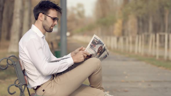 Businessman Relaxing And Reading Fresh Newspaper.Man Rest Sitting On Bench And Reading Newspaper.