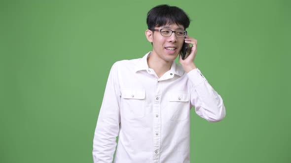 Happy Young Asian Businessman Smiling While Talking on the Phone