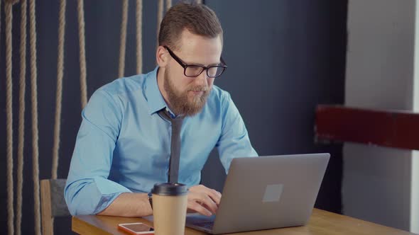 Businessman at the Laptop Indoor.