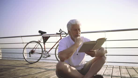 Senior Man Reading Book Sea at Sea Front Slow Motion