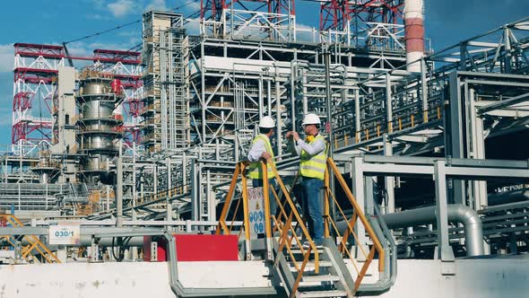 Oil Refinery Employees are Discussing Plant Constructions