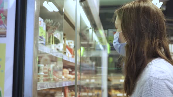 A Young Female Customer Reads the Composition of the Drink on the Juice Bottle