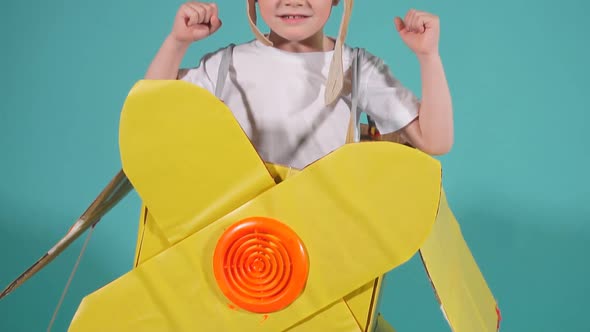 Cheerful Child in Cardboard Airplane