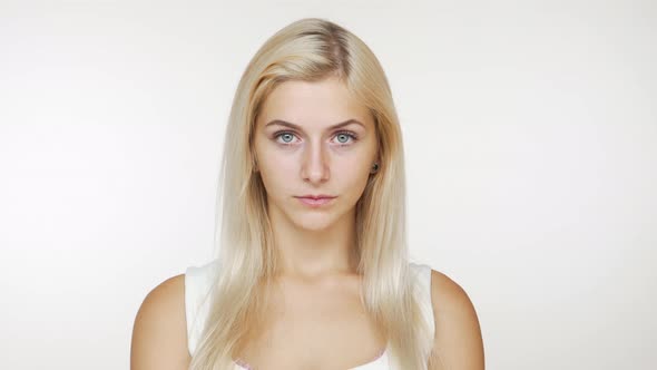 Young Blond Woman Feeling Upset Frustrated Looking at Camera with Tricky Eyes Raising Her Eyebrow