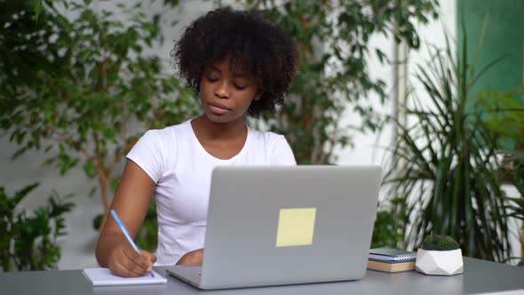 Serious AfricanAmerican Woman Learning Online New Knowledge Remotely Using Laptop and Videocall App