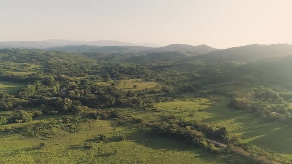 Drone footage panning motion to the right revealing far mountains during a sunrise.