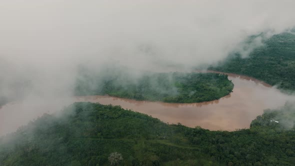 Amazonia River With Tropical Rainforest Covered With Foggy Clouds In Ecuador. Aerial Drone Shot