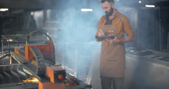 Heavy Industry Worker Controlling the Process of Metal Cutting