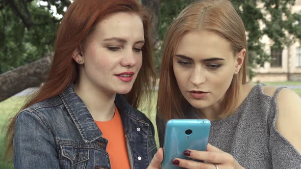 Girls Smiling Ang Talking While Sharing the Phone