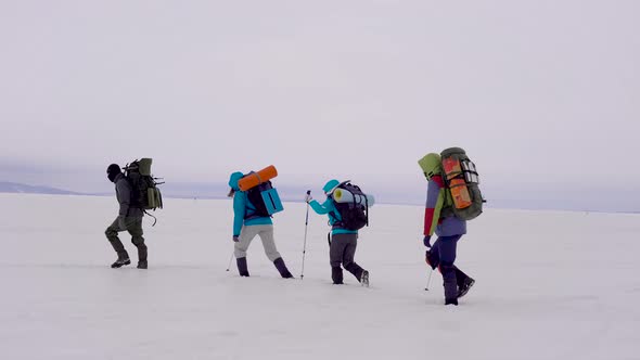 Four Young People Go Hiking in the Snowy Desert