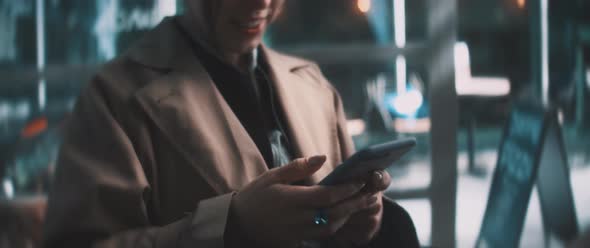 Young woman typing on smartphone and smiling