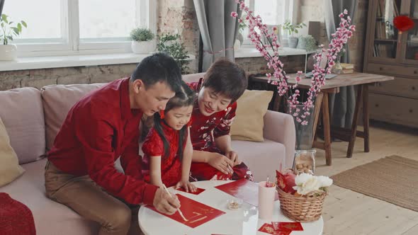 Family Helping Daughter Making Lunar New Year Postcard