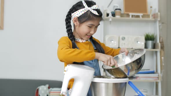 Pretty Asian girl baking homemade bakery cup cake.