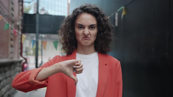 Slow Motion Portrait of Disapproving Businesswoman Showing Thumbsdown Hand Gesture Outdoors