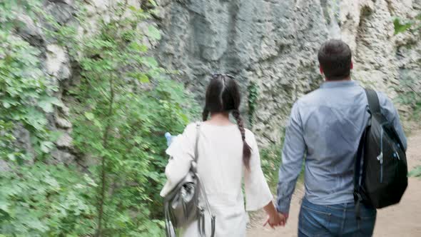 Young Couple Holding Hands and Hiking in the Mountains