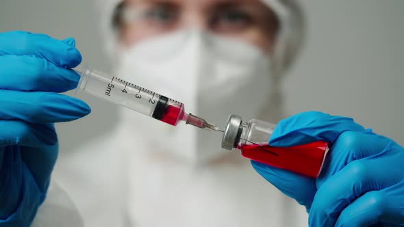 Closeup of Doctor in Protective Medical Uniform Nurse Wearing Face Mask Glasses and Gloves Taking