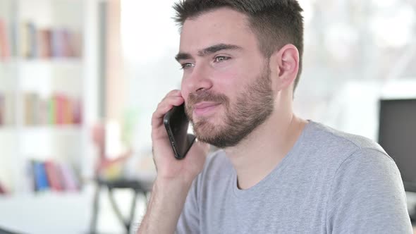 Close Up of Young Man Talking on Smartphone