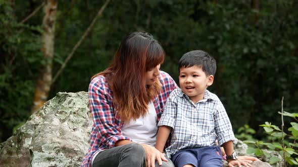 Mother and son sitting relaxed in nature.