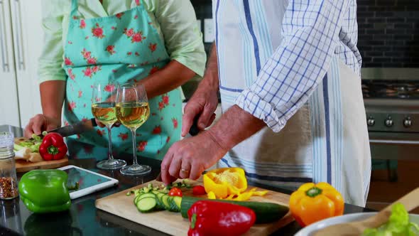 Senior couple cutting vegetables in kitchen 4k