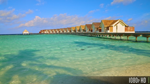 Slow motion traveling along tropical beach with overwater bungalow
