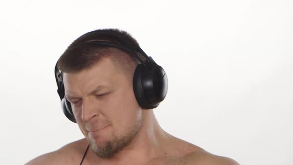Man with Headphones Listening To Music. White