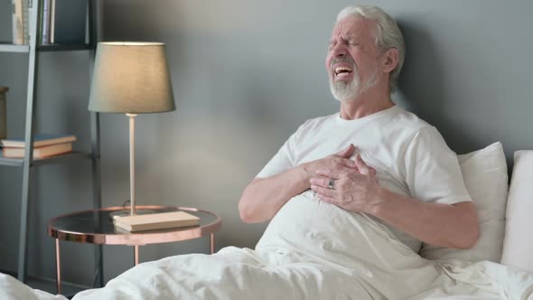 Old Man Having with Chest Pain Sitting in Bed