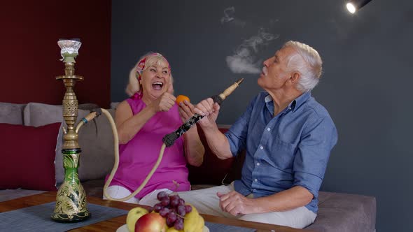 Elderly Couple Smoking Hookah at Home, Senior Grandmother and Grandfather Having Fun, Relaxing