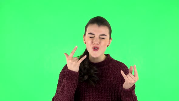 Female Making a Rock Gesture, Enjoying Life and Laughing. Green Screen