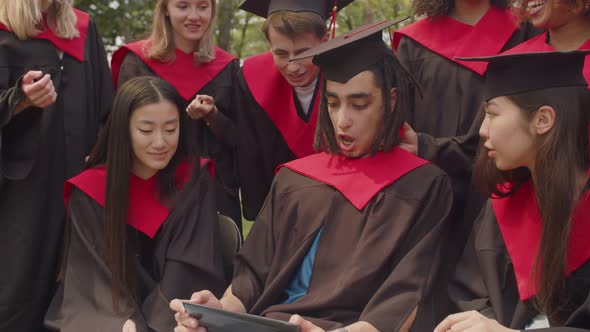 Portrait of Happy Multiracial Graduates Sharing Tablet Pc at Graduation Day