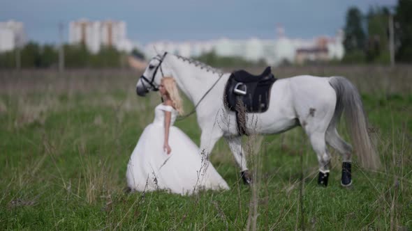 Runaway Bride and Horse are Walking on Field Romantic Woman and White Equine