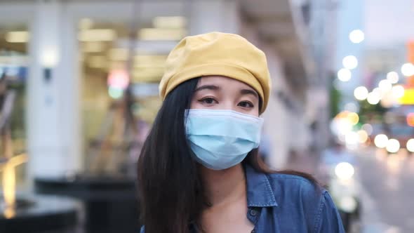 Asian woman standing outdoor wearing protective mask, covid-19 world pandemic