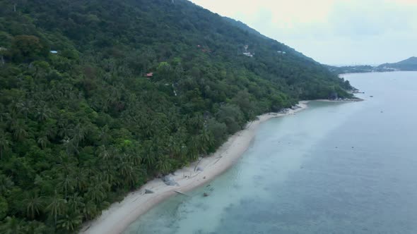 Aerial Descending Over Koh Phangan Empty Beach From High Altitude with Only Two People Swinging on