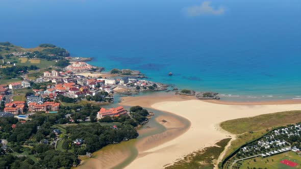 Aerial drone view of summertime holiday coastline in Cantabria Island, pan, day