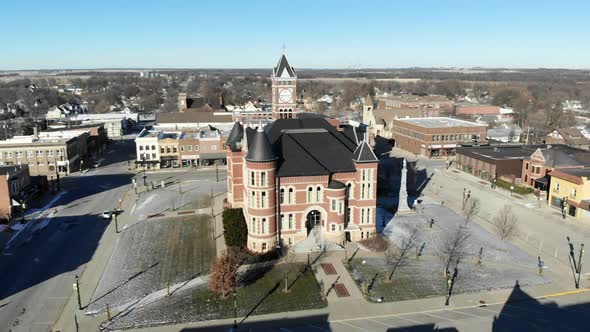 Aerial drone video orbiting around a red brick historic building in the town square
