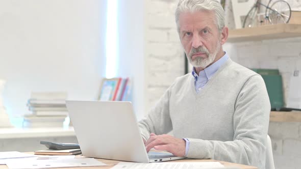 Denying Gesture By Businessman Sitting at Workplace