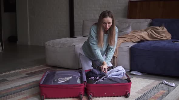 Woman Folding Suitcase Getting Ready for Road Trip Preparing Luggage for Vacation