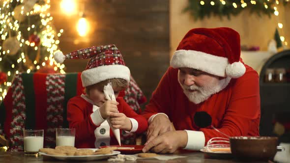 Santa and Child Make Funny Face and Baking Christmas Cookies in the Vintage Kitchen.