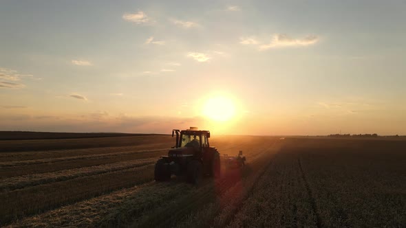 Drone View: A Tractor Cultivates The Land At Sunset.