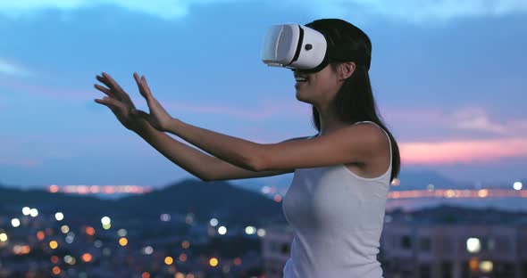 Woman watching on VR device in the evening 