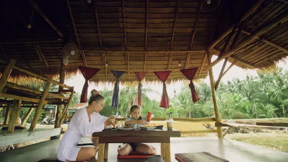 The Happy Family Eat and Drink Tasty Beverages Spending Time in Local Floating Cafe on Water