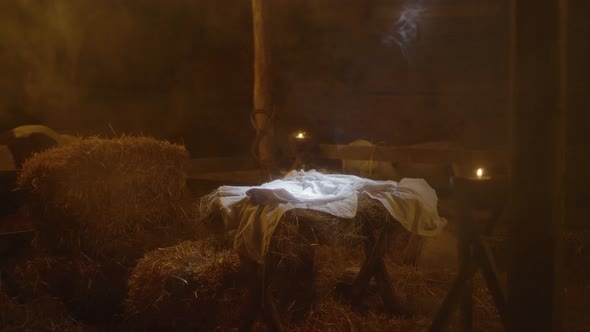 Illuminated Manger with Blanket in Dim Stable on Christmas Day