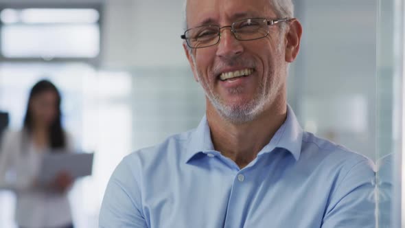 Portrait of man crossing his arms and smiling in office