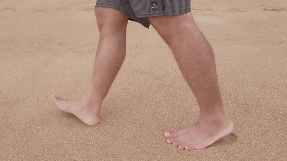 POV of man walking with barefoot on white sand beach in slow-motion in summer holiday vacation