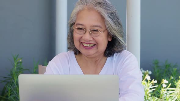 Asian elderly woman online video call on laptop computer