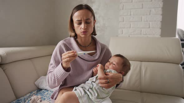 Mother Measuring Temperature of Her Ill Kid at Background